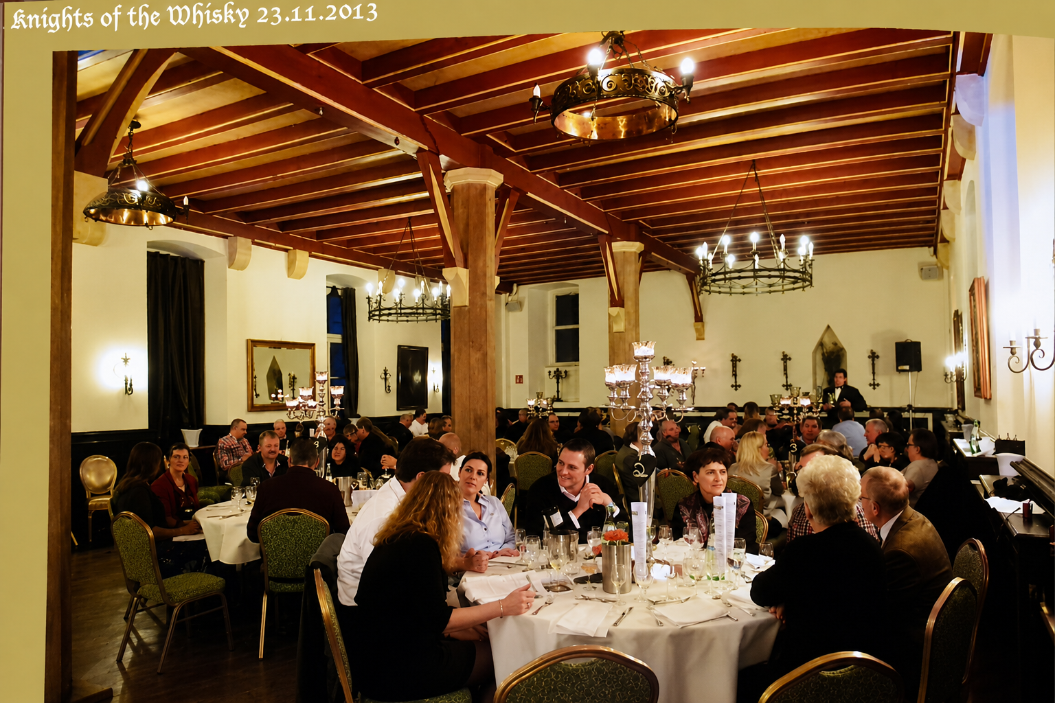 Großer Speisesaal mit gedeckten runden Tischen, Kronleuchtern und Gästen beim Whisky-Dinner „Knights of the Whisky“ am 23.11.2013.