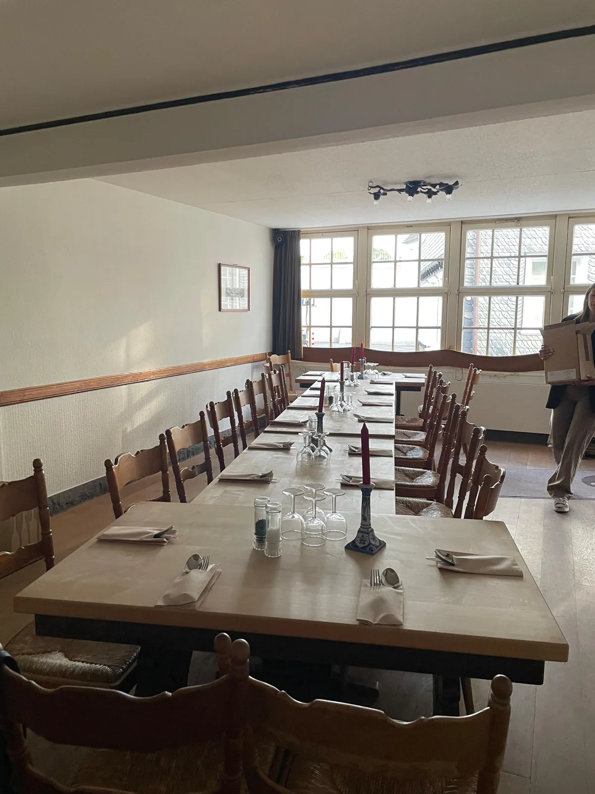 Lange, festlich eingedeckte Tafel im leeren Gastraum