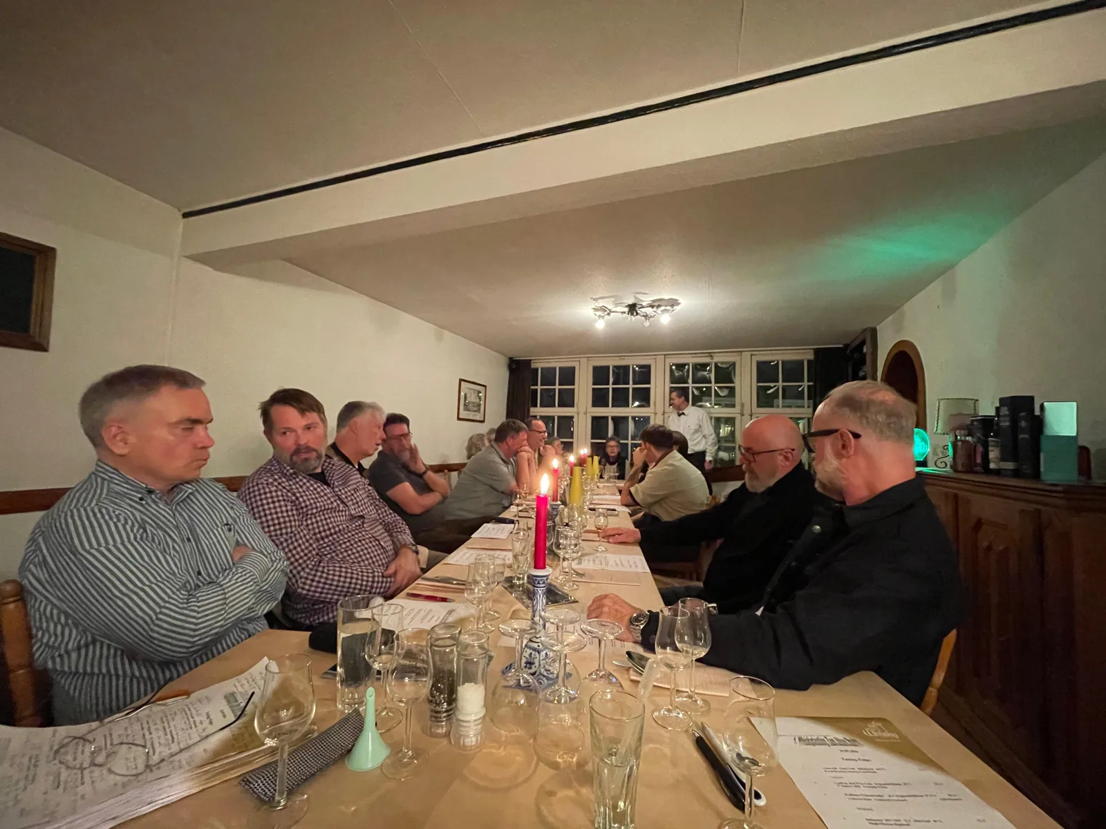 Gäste mit Tastinggläsern an der langen Tafel